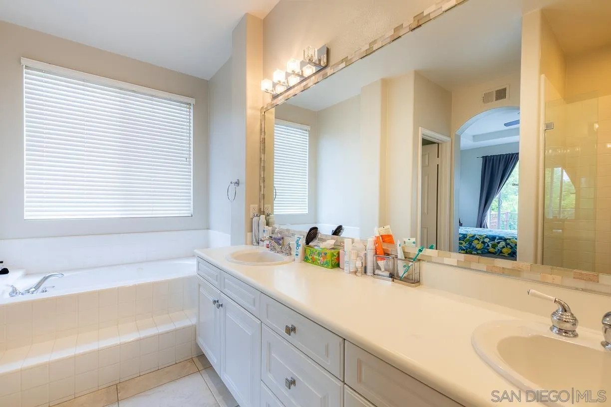 2435 Ridgegate Row La Jolla, CA 92037 - Photo 16 of 30 a bathroom with a tub sink and mirror