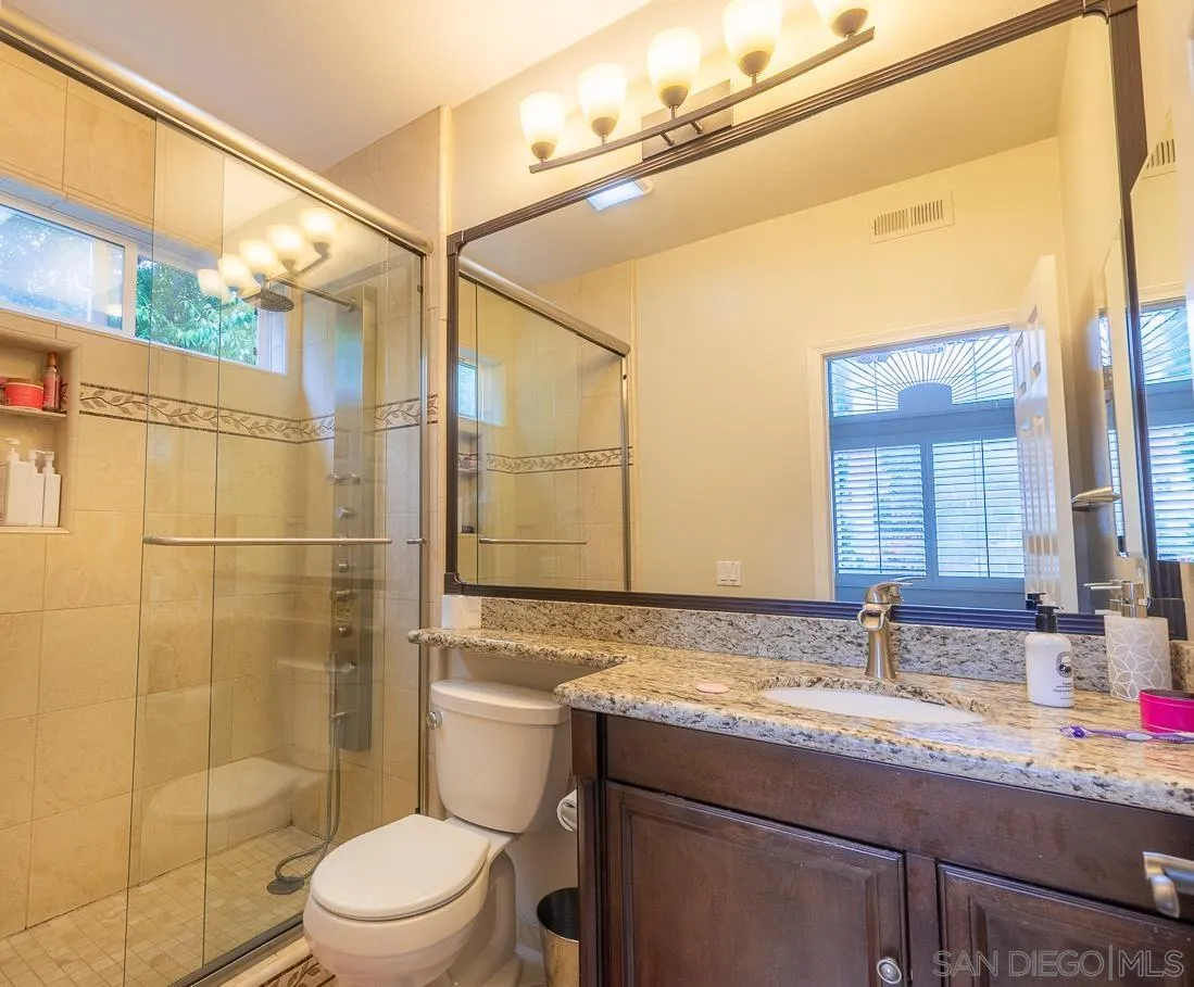 2435 Ridgegate Row La Jolla, CA 92037 - Photo 18 of 30 a bathroom with a granite countertop sink toilet and shower