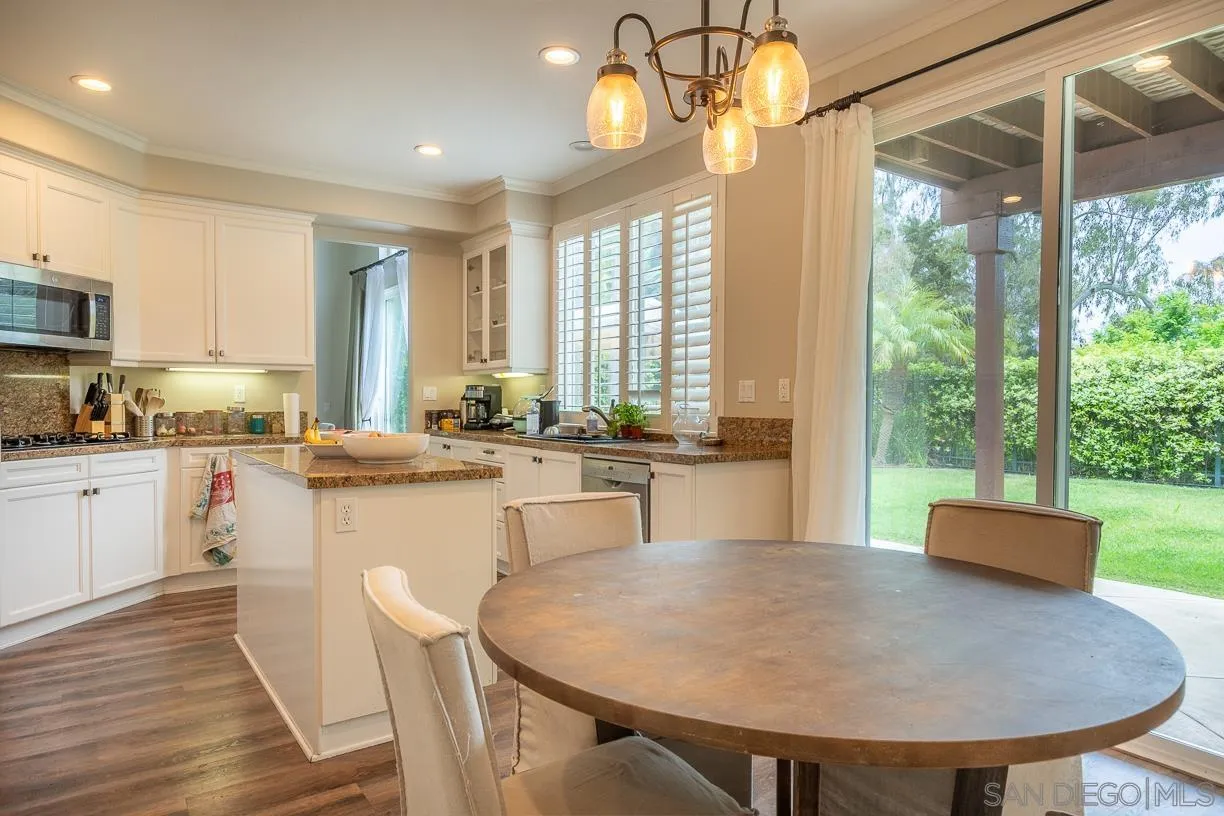 2435 Ridgegate Row La Jolla, CA 92037 - Photo 9 of 30 a kitchen with a table chairs and microwave
