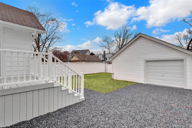 a view of a house with a small yard and large tree