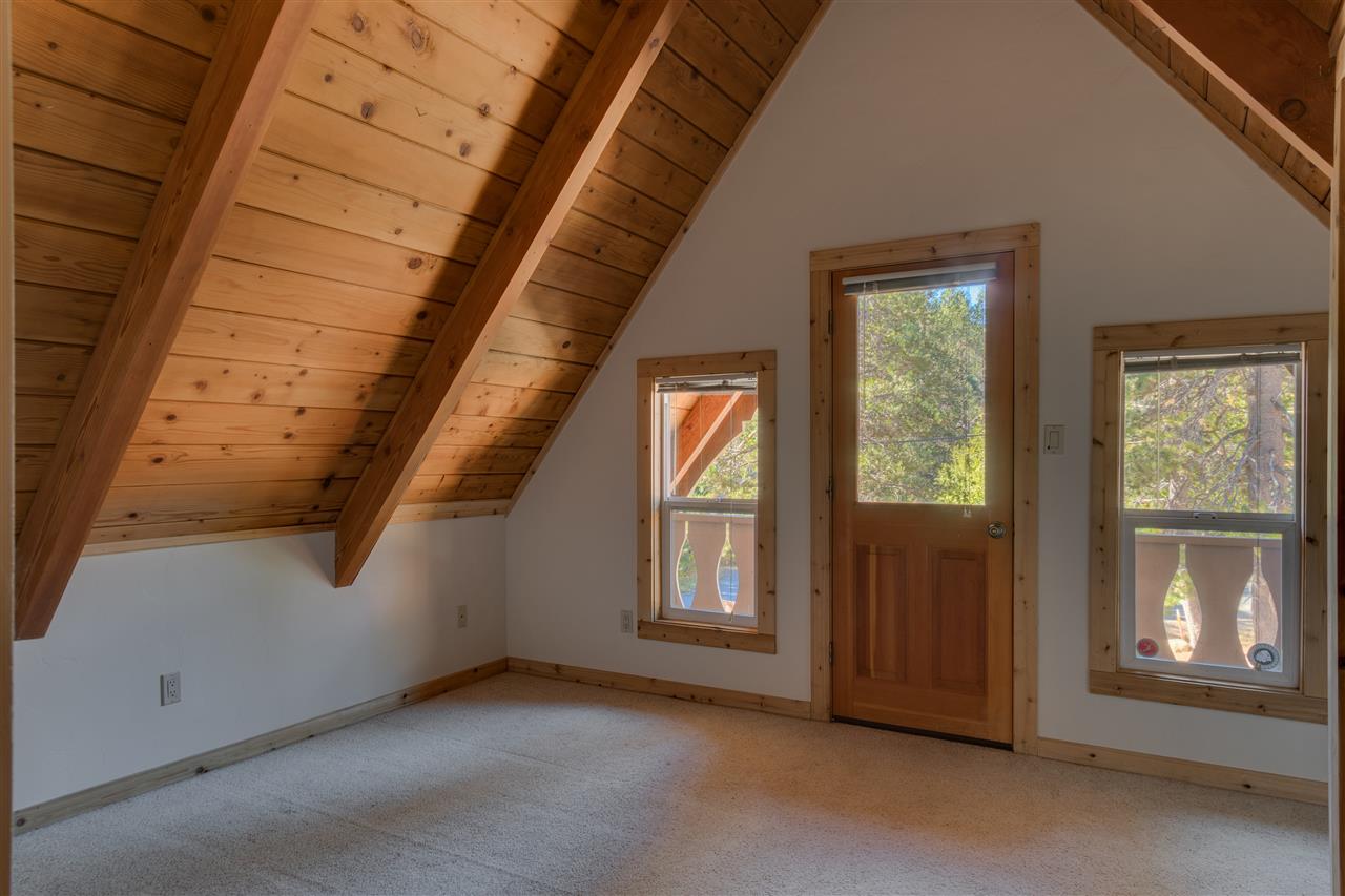 Located upstairs, this bedroom has vaulted ceilings and a cute deck.