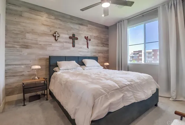 a large bed sitting in a bedroom next to a window and a chandelier