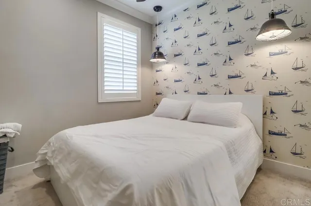 a bedroom with a bed and a lamp next to a window