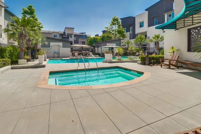 a view of backyard with swimming pool and seating space