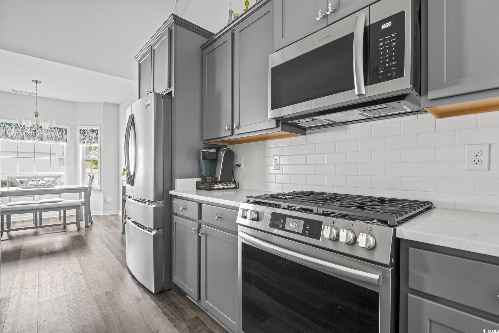 308 Concorde Drive Georgetown, SC 29440 - Photo 13 of 40 Beautiful Kitchen featuring stainless steel appliances including nearly new gas stove, gray cabinetry, custom cabinet pulls, tasteful backsplash, granite countertops
