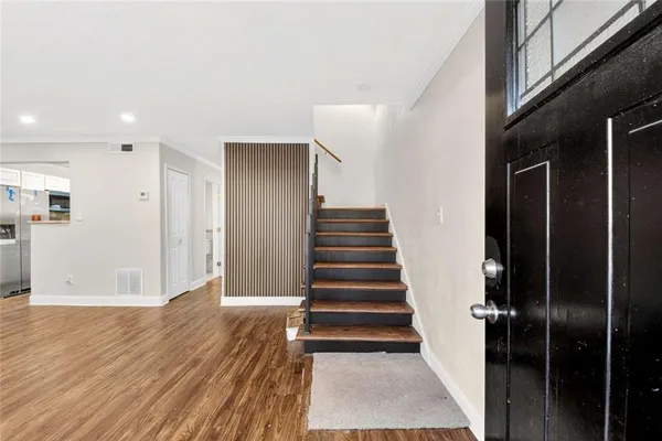 a view of a hallway with wooden floor and entryway