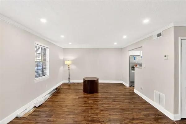 a view of empty room with wooden floor and window