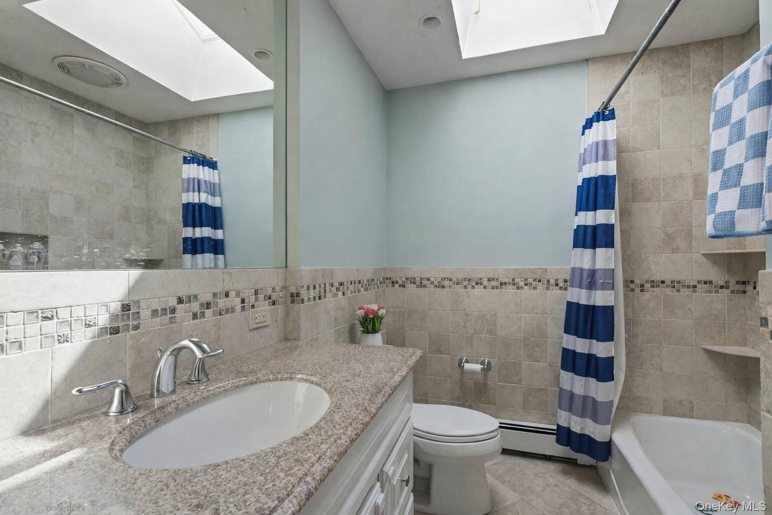 12 Sherman Road Glen Cove, NY 11542 - Photo 18 of 27 a bathroom with a granite countertop bathtub sink vanity mirror and toilet