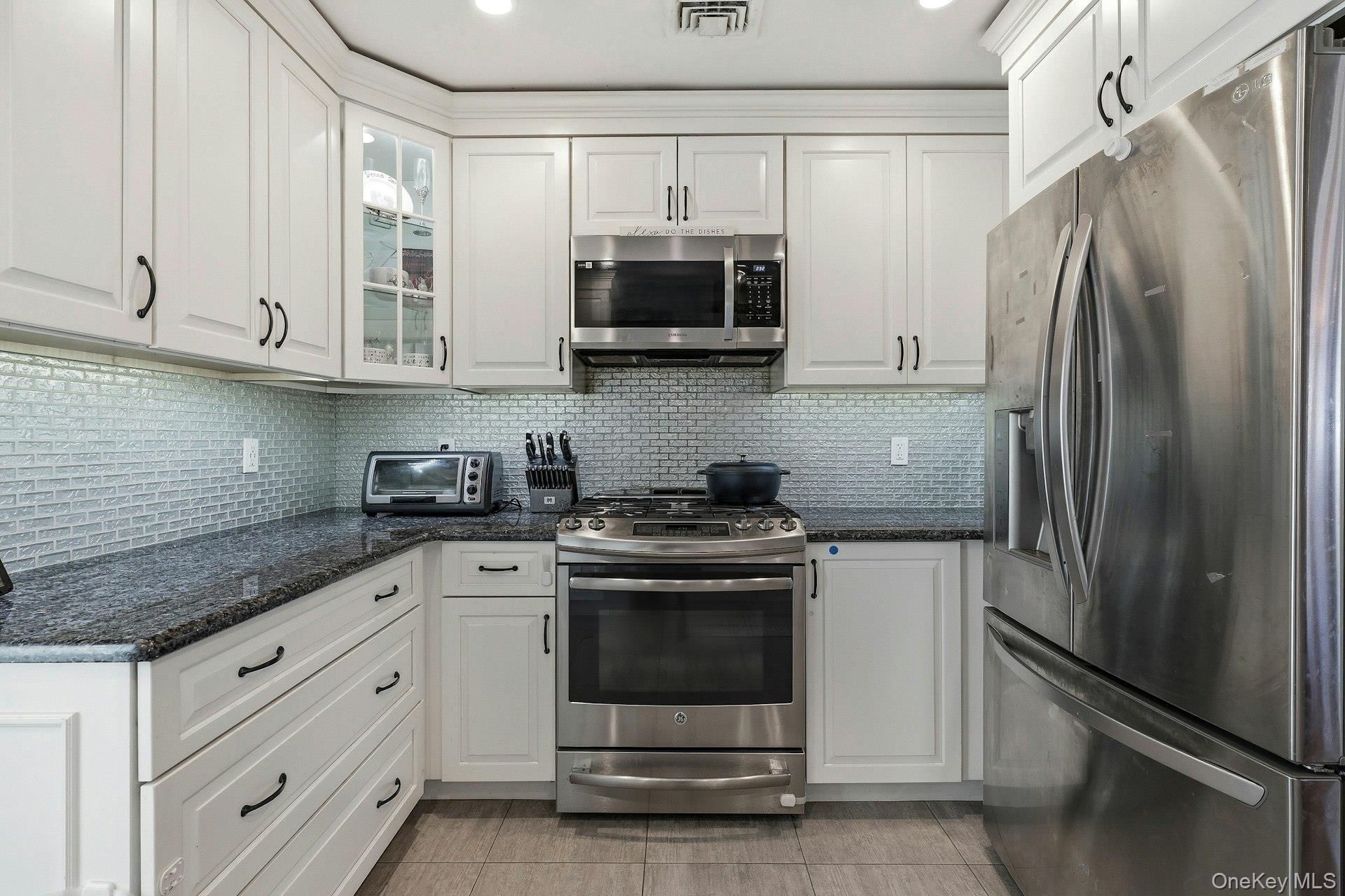 12 Sherman Road Glen Cove, NY 11542 - Photo 7 of 27 a kitchen with stainless steel appliances granite countertop a refrigerator stove and sink