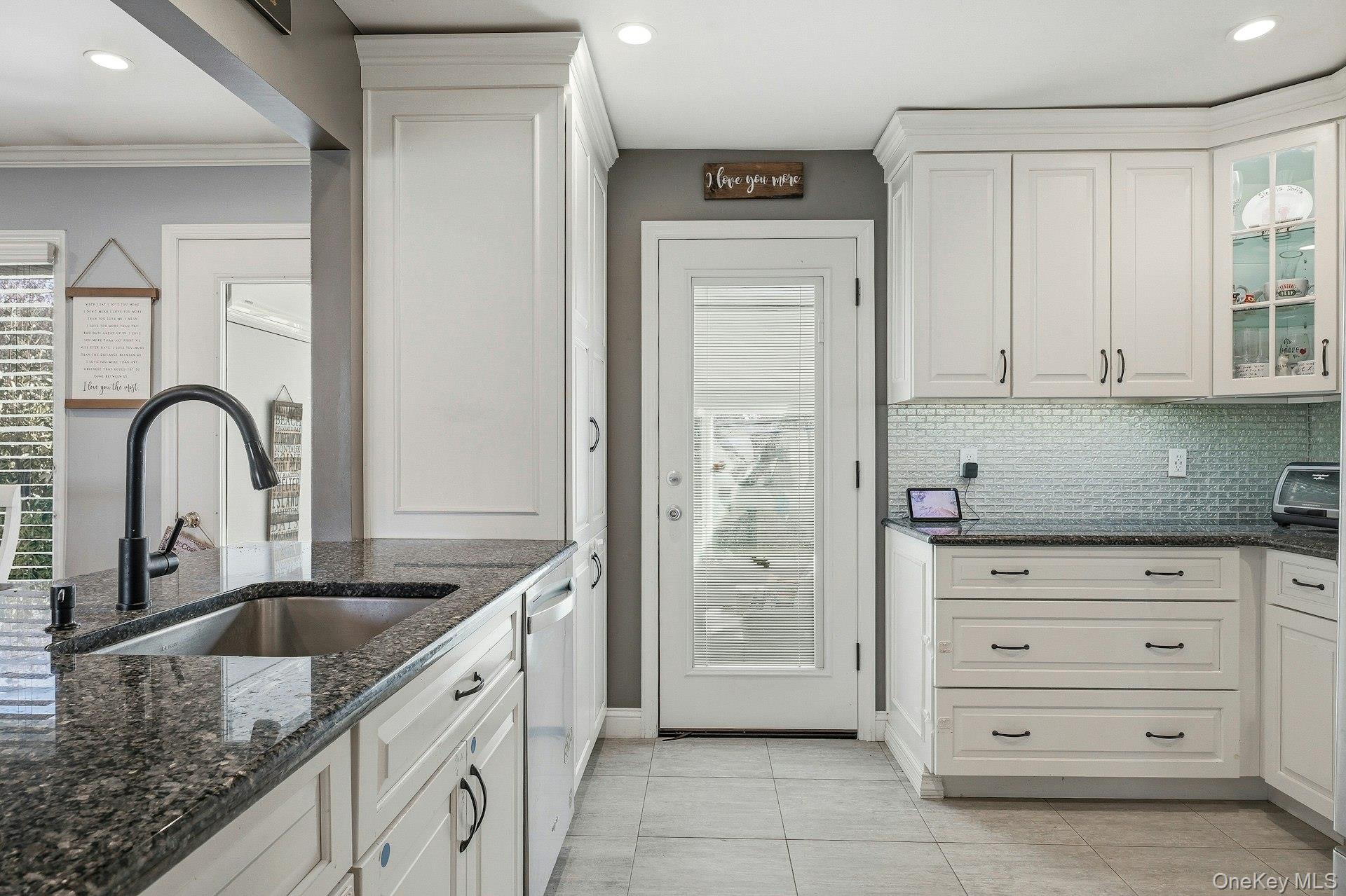 12 Sherman Road Glen Cove, NY 11542 - Photo 8 of 27 a kitchen with granite countertop a sink a stove and cabinets