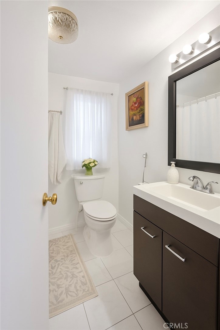 4117 West McFadden Avenue Santa Ana, CA 92704 - Photo 8 of 11 a bathroom with a toilet sink and mirror