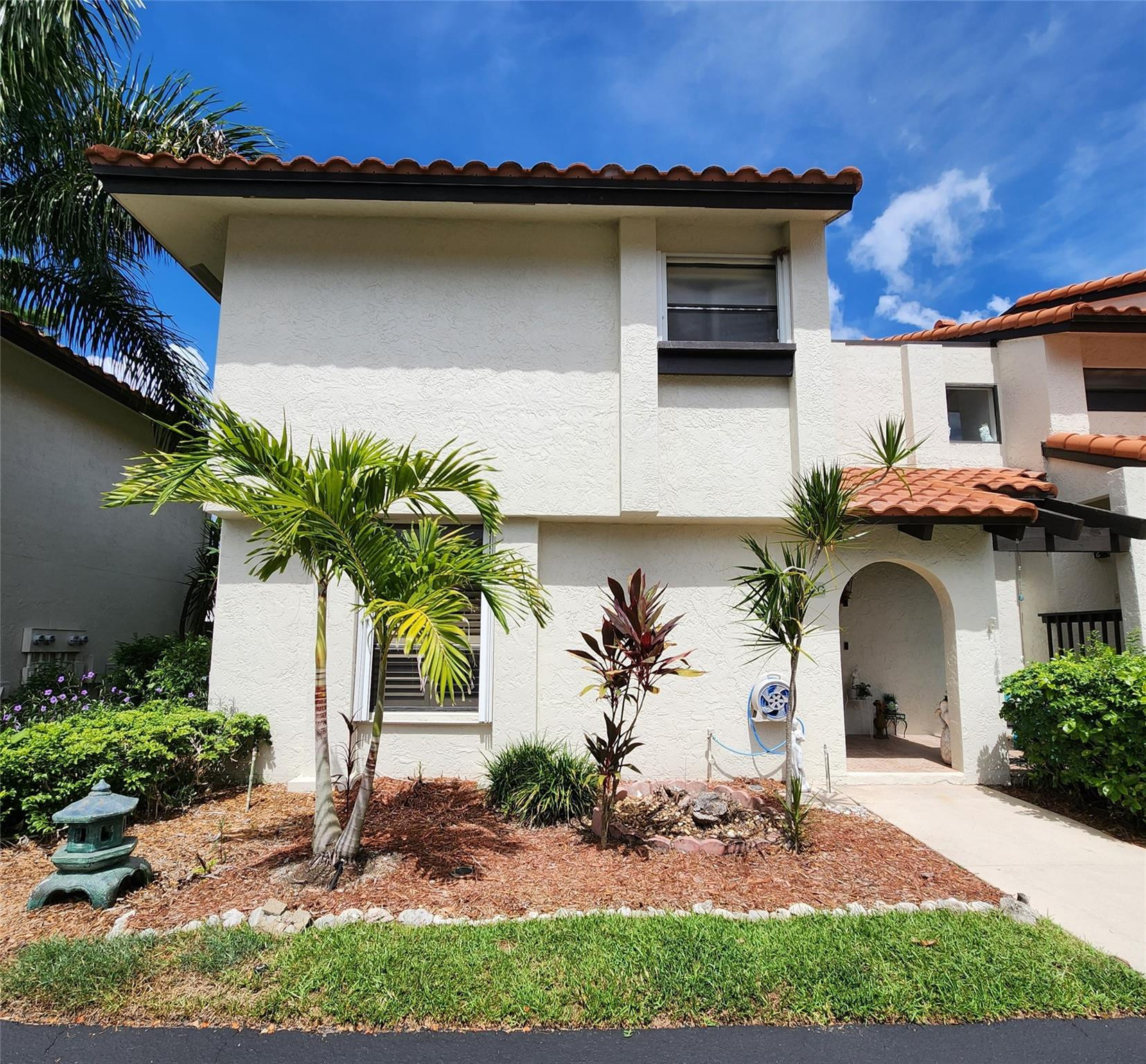 5762 Fox Hollow Drive, Unit G Boca Raton, FL 33486 - Photo 1 of 53 a front view of a house with a garden and outdoor seating