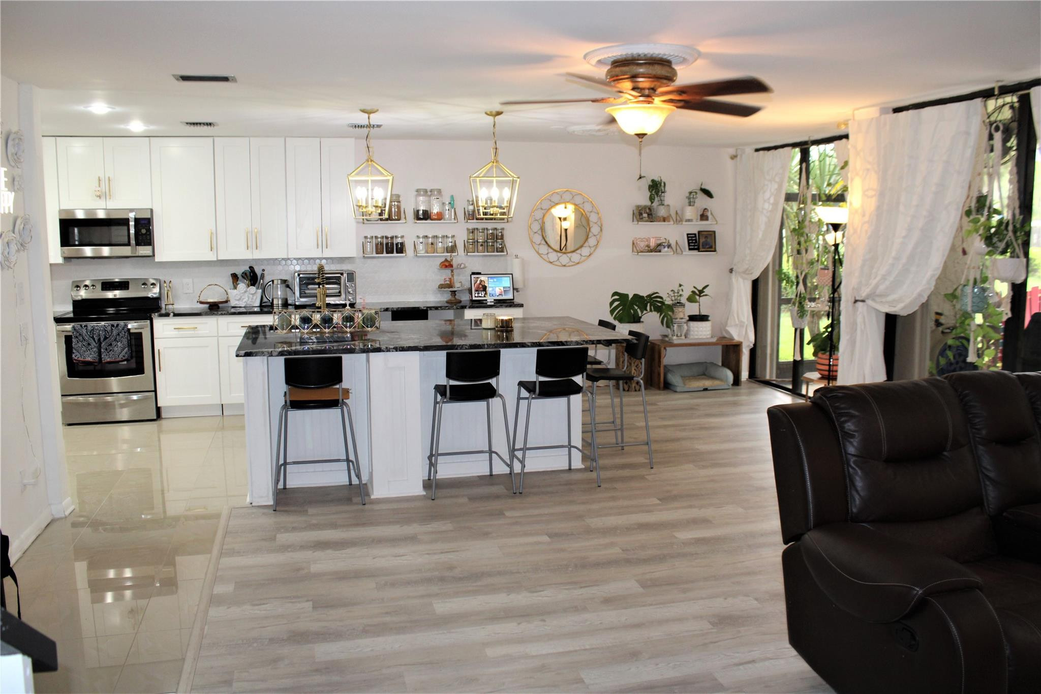 5762 Fox Hollow Drive, Unit G Boca Raton, FL 33486 - Photo 24 of 53 a living room with furniture a chandelier and kitchen view