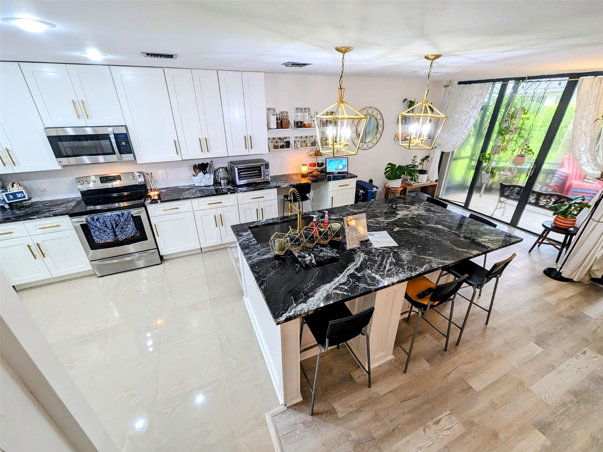 5762 Fox Hollow Drive, Unit G Boca Raton, FL 33486 - Photo 9 of 53 a kitchen with stainless steel appliances granite countertop a stove top oven a sink dishwasher and white cabinets with wooden floor