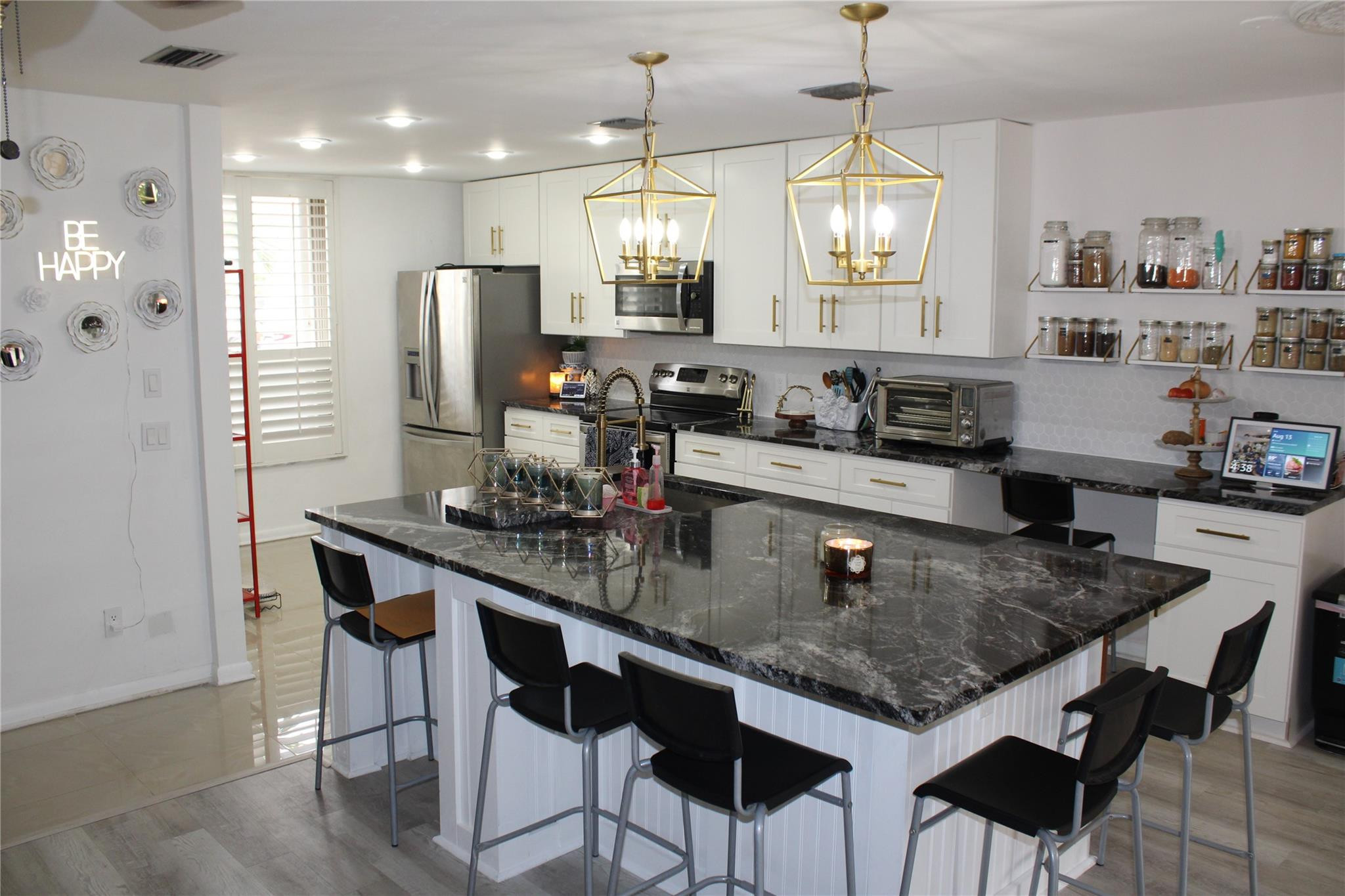 5762 Fox Hollow Drive, Unit G Boca Raton, FL 33486 - Photo 10 of 53 a kitchen with stainless steel appliances granite countertop a kitchen island a stove a table and chairs