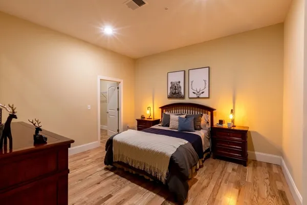 a bedroom with a bed and wooden floor