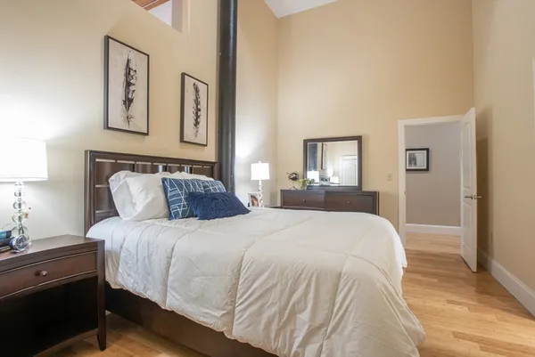 a bedroom with bed and painting on the wall