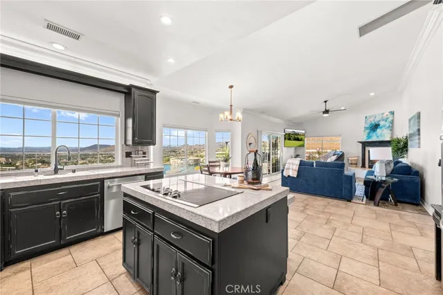a kitchen with stainless steel appliances kitchen island granite countertop a dining table chairs and refrigerator