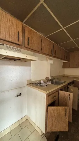 a kitchen with a sink a stove and cabinets