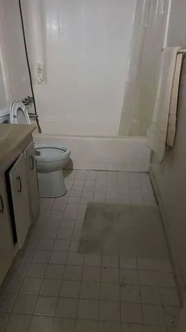 a bathroom with a granite countertop sink a toilet and a mirror