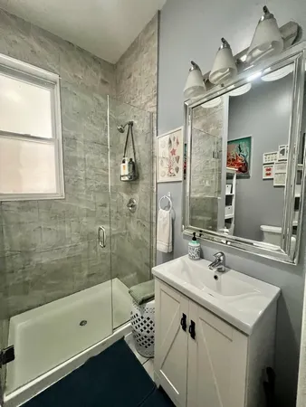 a bathroom with a sink a large mirror and a shower