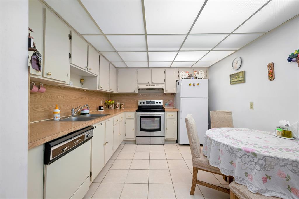 1301 Northeast 7th Street, Unit 113 Hallandale Beach, FL 33009 - Photo 12 of 45 a kitchen with stainless steel appliances a stove a sink and cabinets