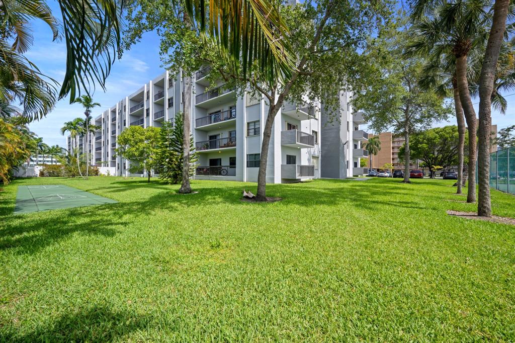1301 Northeast 7th Street, Unit 113 Hallandale Beach, FL 33009 - Photo 32 of 45 a front view of a building with a garden