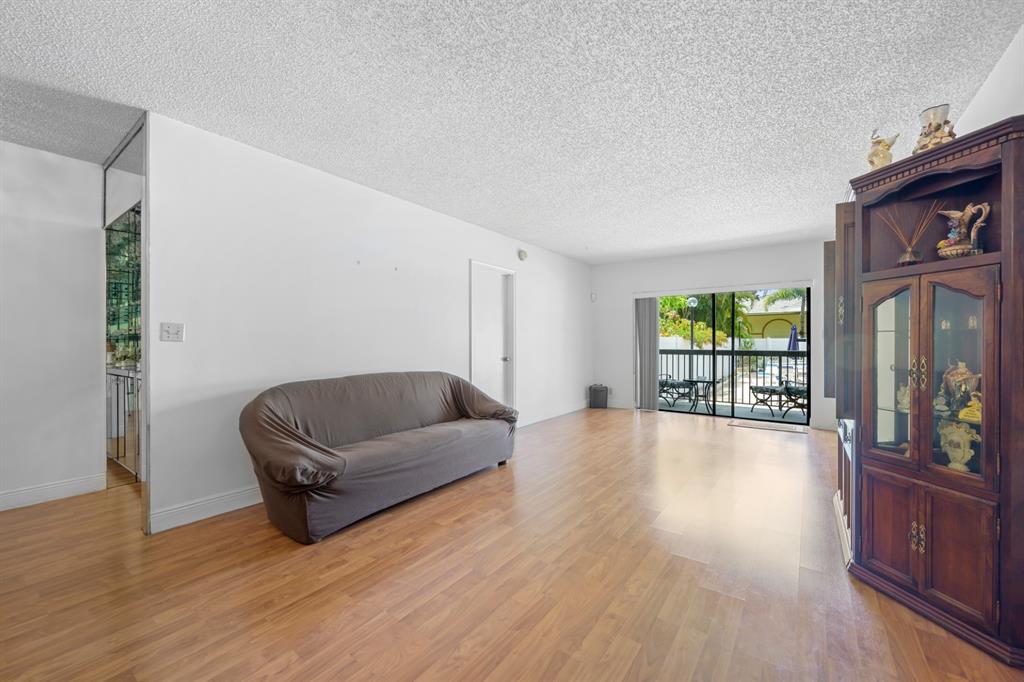 1301 Northeast 7th Street, Unit 113 Hallandale Beach, FL 33009 - Photo 6 of 45 a living room with furniture and a flat screen tv