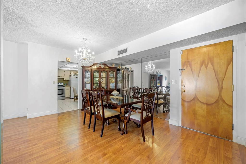 1301 Northeast 7th Street, Unit 113 Hallandale Beach, FL 33009 - Photo 10 of 45 a view of a dining room with furniture and wooden floor