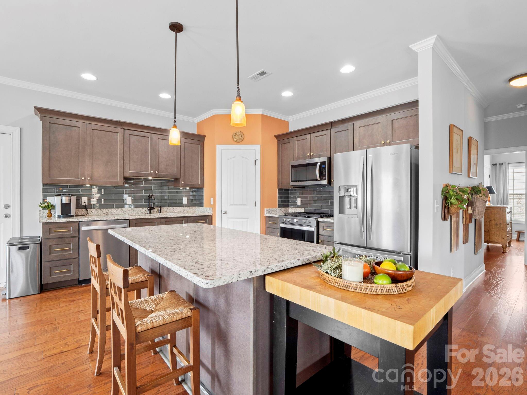 614 Downing Way Landrum, SC 29356 - Photo 11 of 46 a kitchen with stainless steel appliances granite countertop a sink a stove a refrigerator cabinets a dining table and chairs