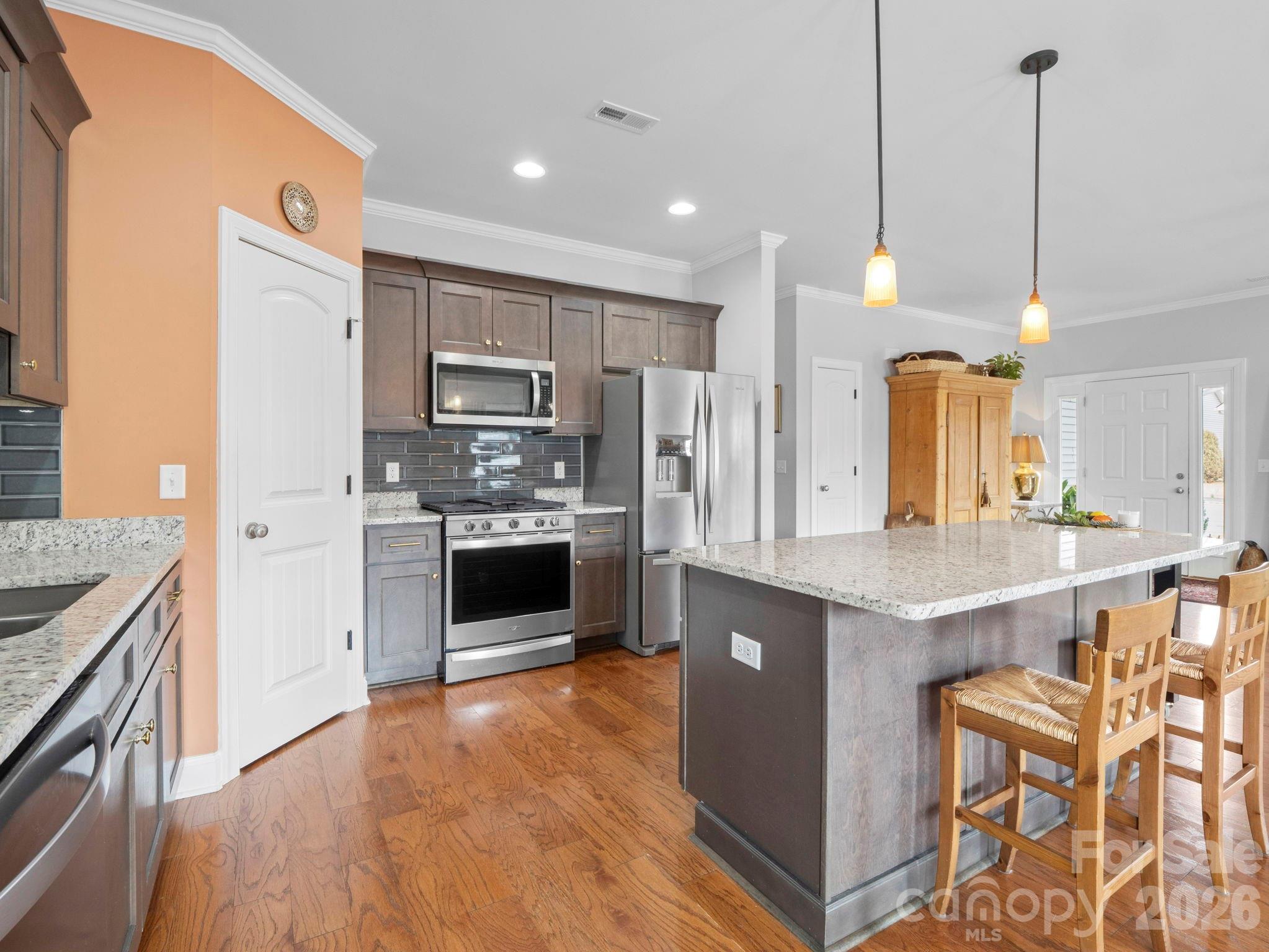 614 Downing Way Landrum, SC 29356 - Photo 13 of 46 a kitchen with stainless steel appliances kitchen island granite countertop a stove a sink a refrigerator and a oven with wooden floor