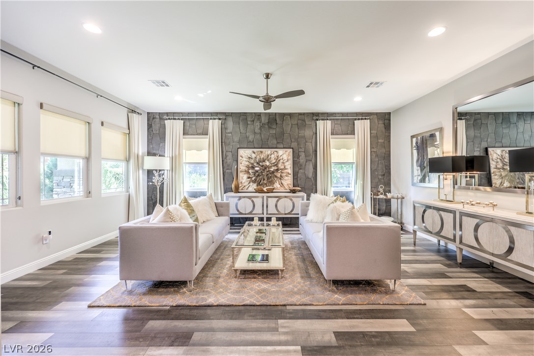 7119 Arabian Ridge Street Las Vegas, NV 89131 - Photo 9 of 73 Recessed lighting and a ceiling fan adorn this spacious living room, featuring variegated flooring and natural light.