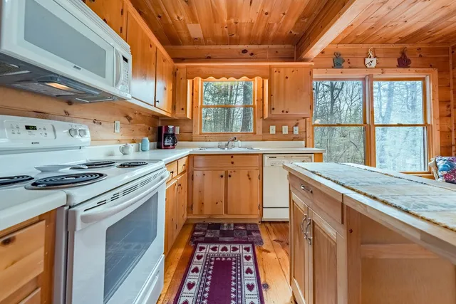 a kitchen with stainless steel appliances granite countertop a stove a sink and a granite counter tops with wooden floors