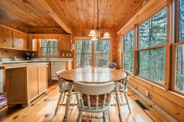 a dining room with stainless steel appliances granite countertop a sink a stove a refrigerator with a dining table and chairs with wooden floor
