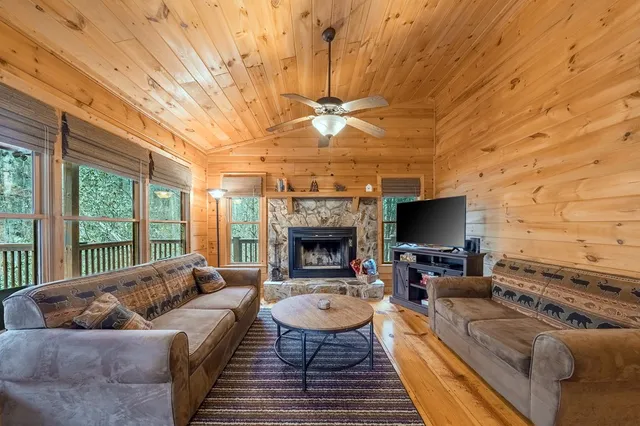 a living room with furniture a fireplace and a flat screen tv