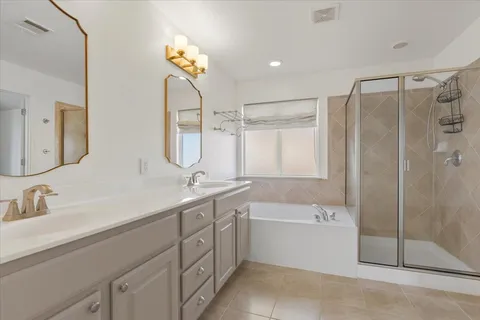 a bathroom with a double vanity sink mirror and bathtub