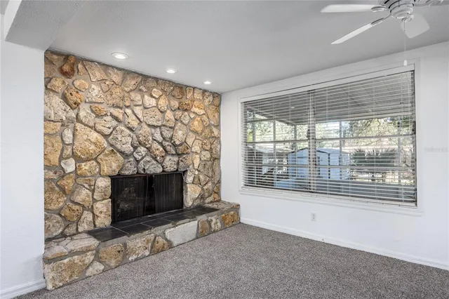 a living room with a fireplace and a floor to ceiling window