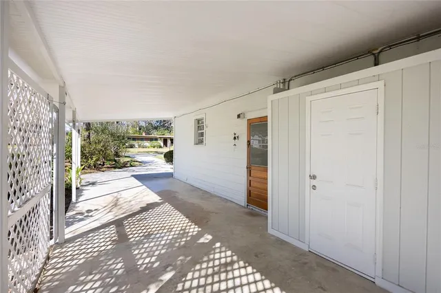 a view of a hallway with wooden floor and a living room