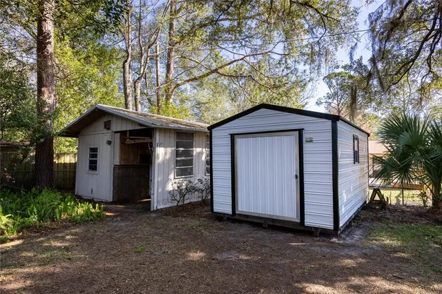 a view of a house with a yard and a large tree