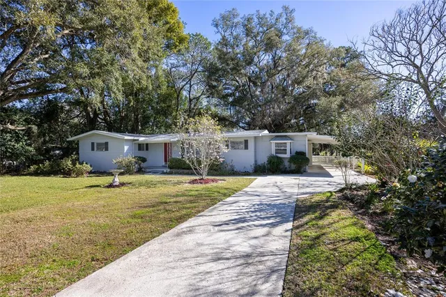 a front view of a house with a yard and trees