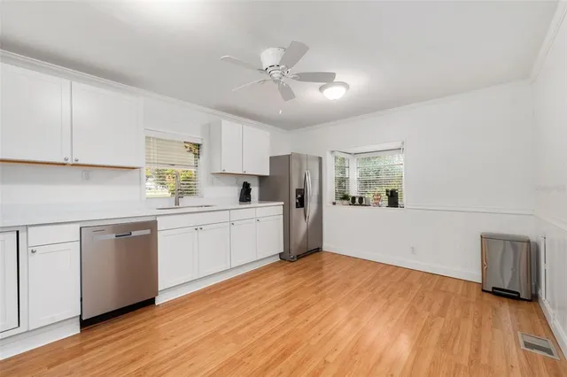 a kitchen with white cabinets and white appliances