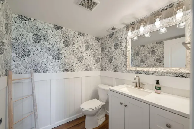 a bathroom with a toilet sink and mirror