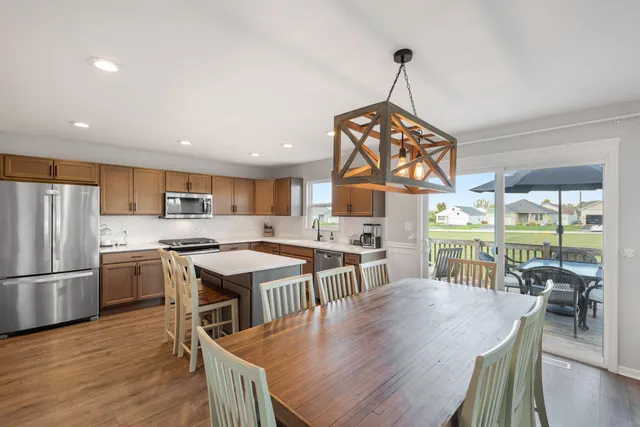 a view of a dining room and livingroom with furniture wooden floor a chandelier