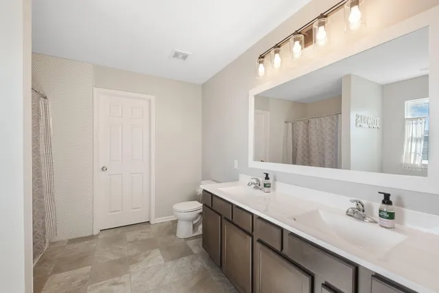 a bathroom with a sink double vanity and a mirror