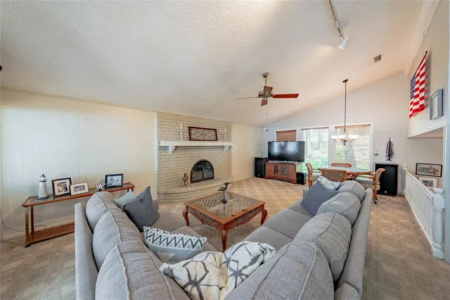 a living room with furniture a fireplace and kitchen view