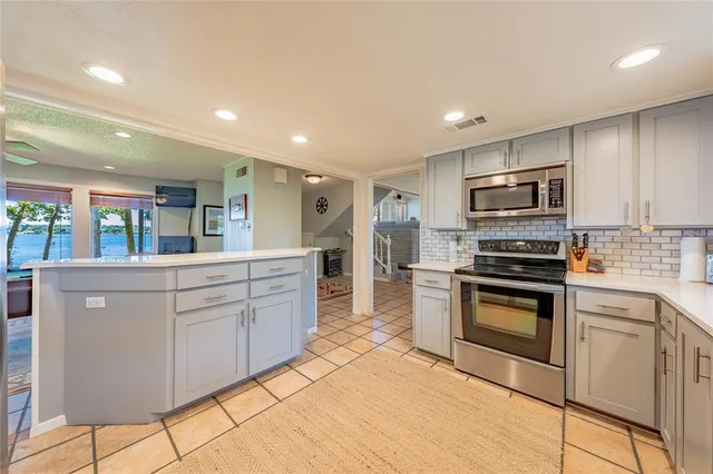 a kitchen with stainless steel appliances granite countertop a stove a sink and a refrigerator