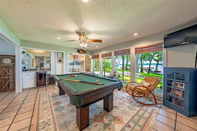 a room with pool table and windows