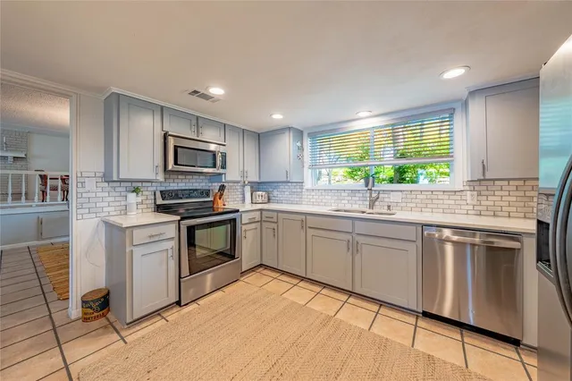 a kitchen with kitchen island granite countertop a stove sink and microwave