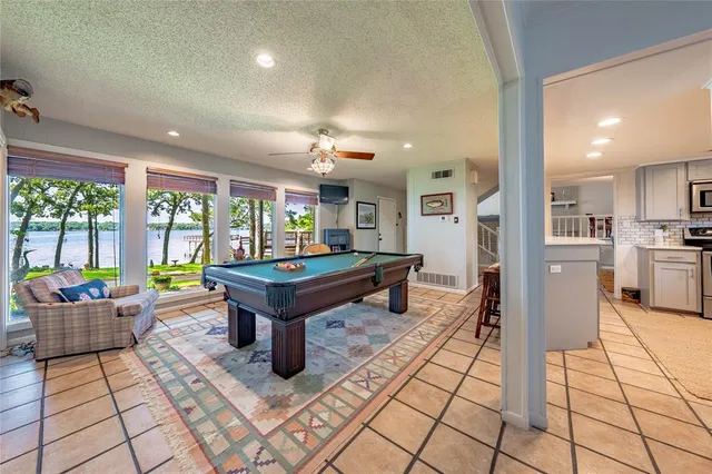 a room with pool table and windows
