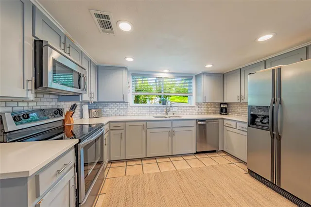 a kitchen with a refrigerator stove top oven and sink